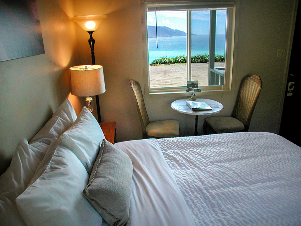 Honeymoon cottage bedroom at Lucia Lodge with four-poster queen bed and black entry door