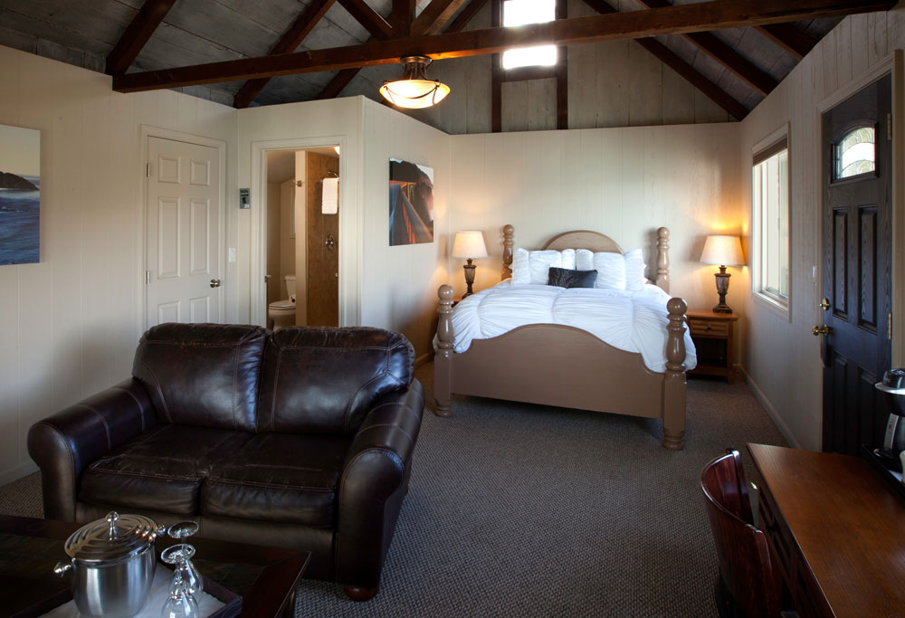 Vaulted wood-beam ceiling and ocean-view sitting area in the Lucia Lodge honeymoon cottage