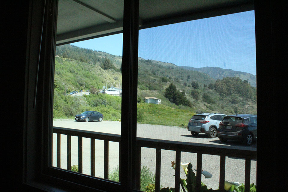 Mountain view room at Lucia Lodge with exposed wood beam ceiling and sofa bed