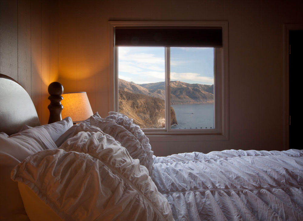 Sitting area and bed in an Oceanview Luxury cabin at Lucia Lodge