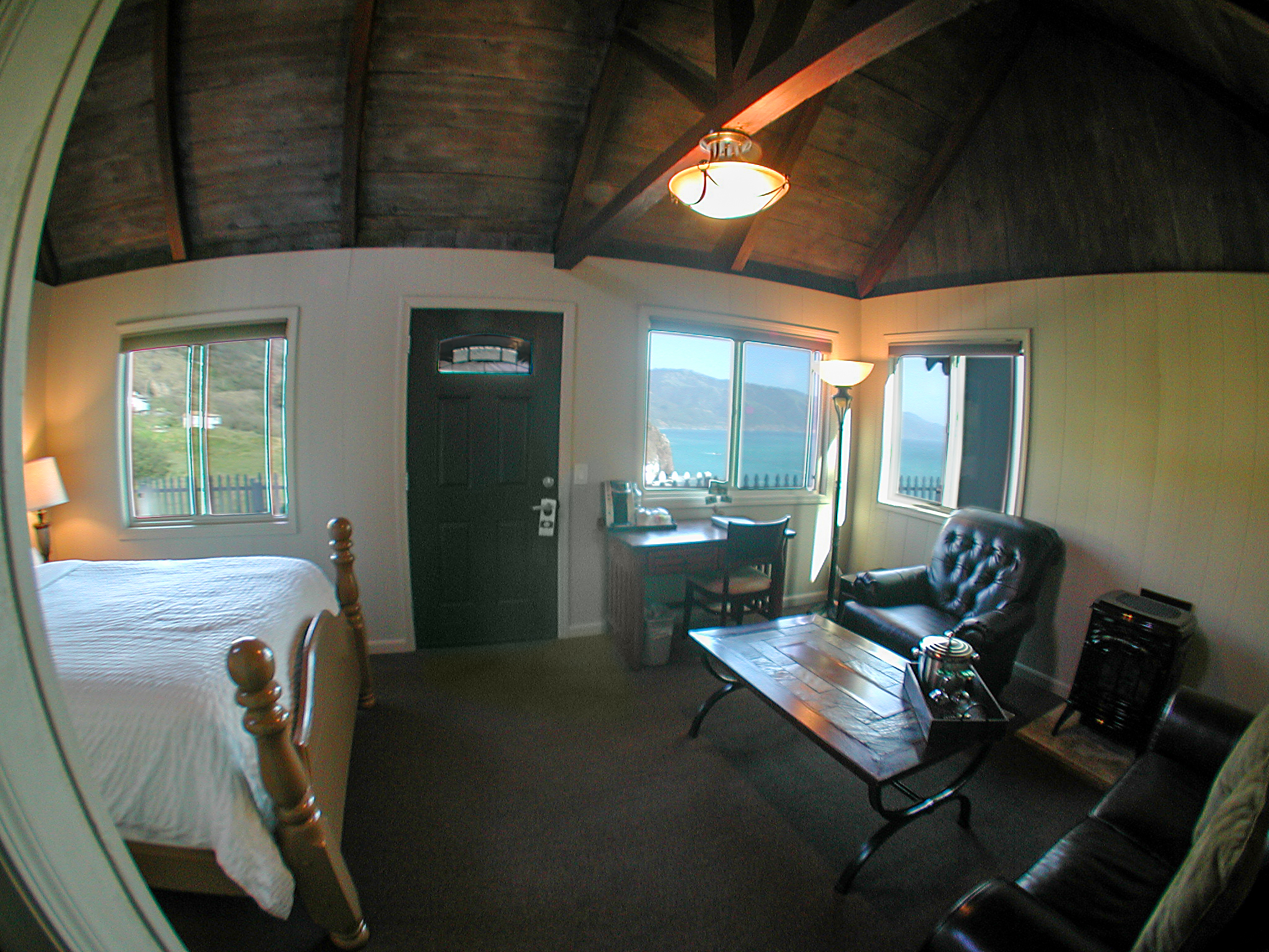 Wide view of an Oceanview Luxury cabin at Lucia Lodge with vaulted wood ceiling and ocean-facing windows